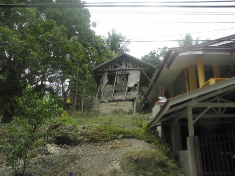 Image of decrepid
        house untouched by earthquake
